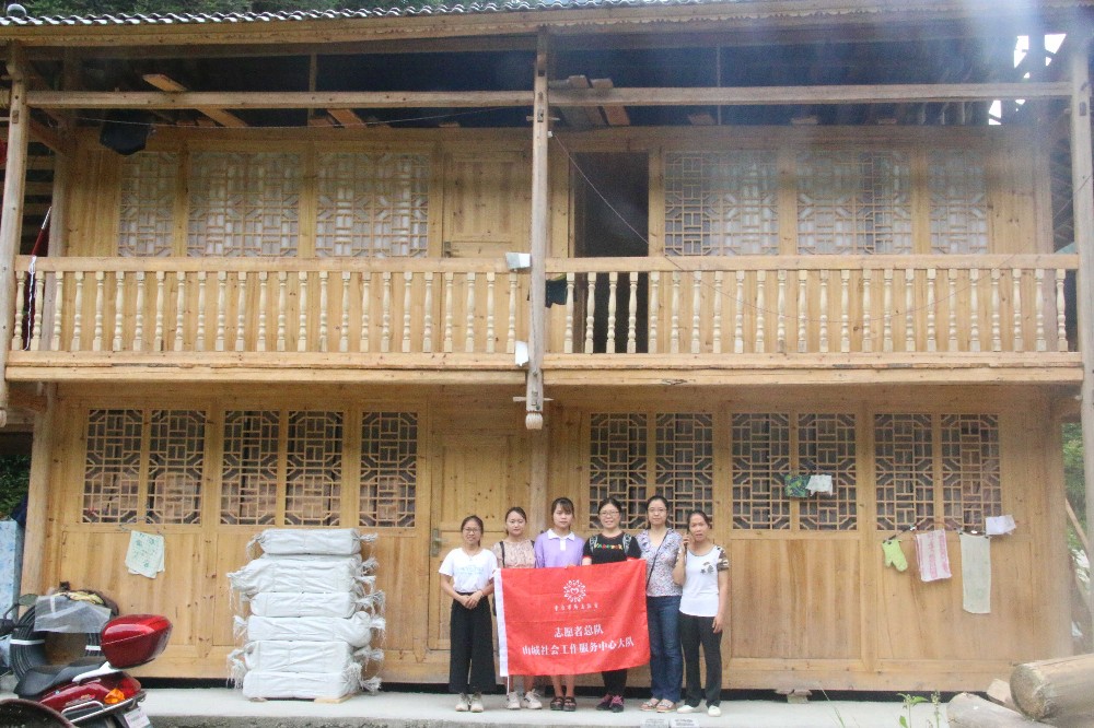 2019年志愿者们在村民杨梦新建的木楼前合影.jpg