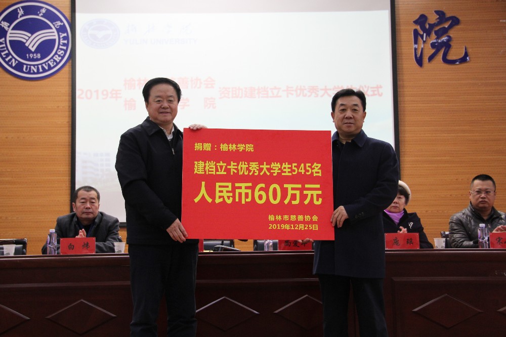 市慈善协会会长刘洪（左）向榆林学院递交捐赠牌.JPG