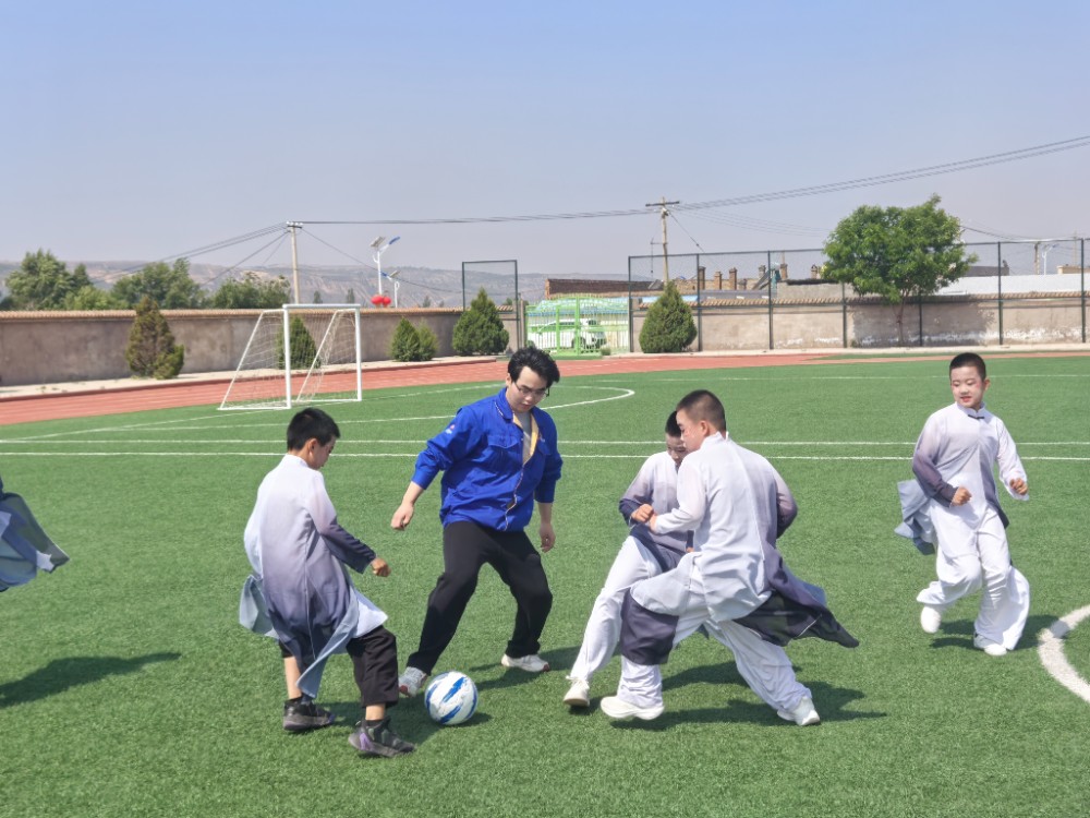 5.慈善志愿者与孩子们在足球场上激情互动.jpg