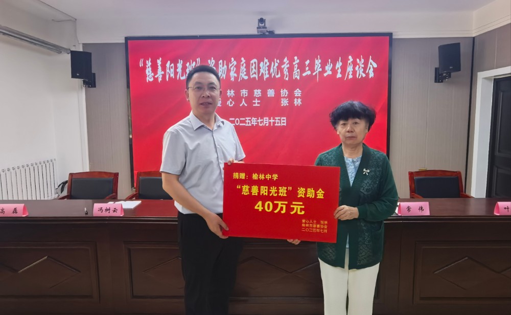 2.榆林市慈善协会副会长庞瑶（右）向榆林中学递交捐赠牌.jpg