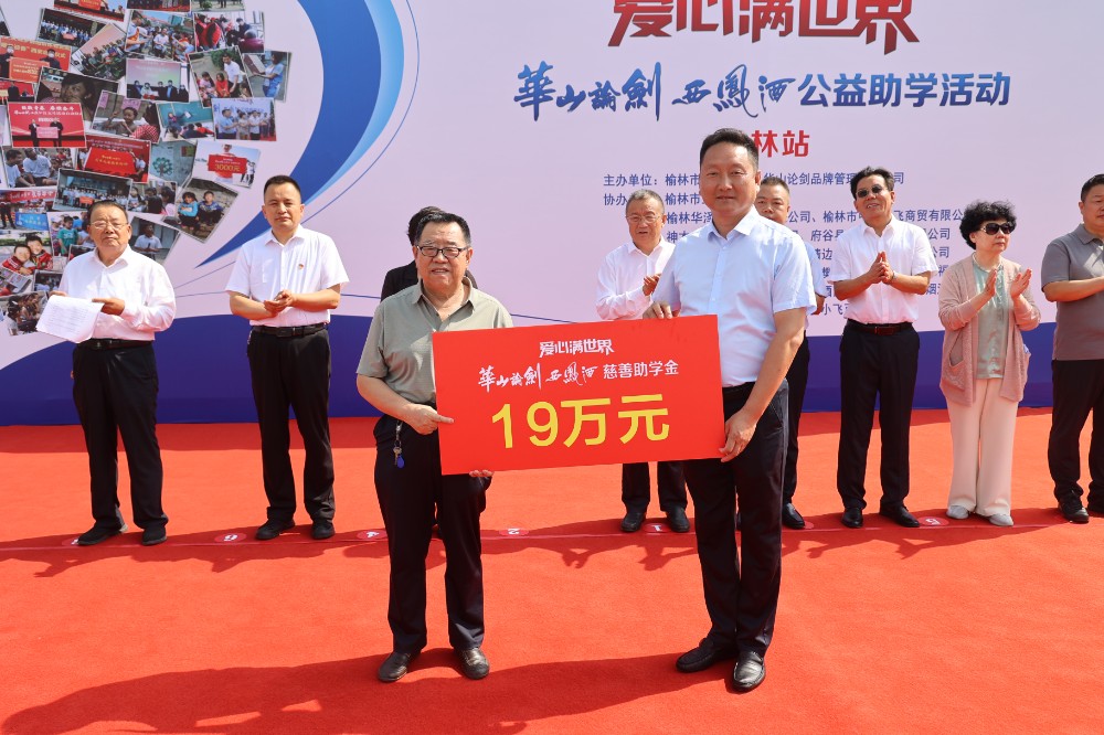 华山论剑品牌管理有限公司外埠销售公司纪委书记程加理（右）向榆林市慈善协会副会长张榆生（左）递交捐赠牌.jpg