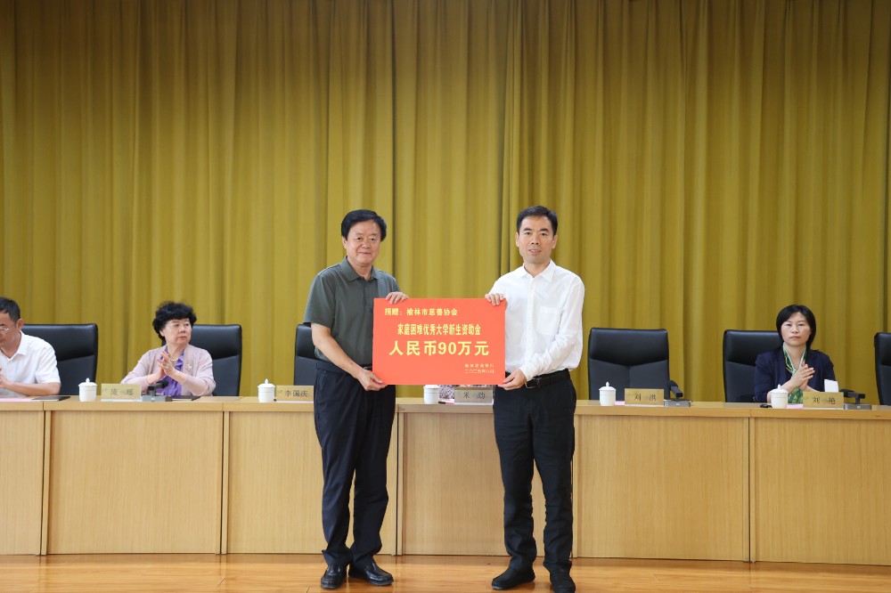 5.榆林农商银行董事长李国庆向榆林市慈善协会会长刘洪（左）递交捐赠牌.JPG