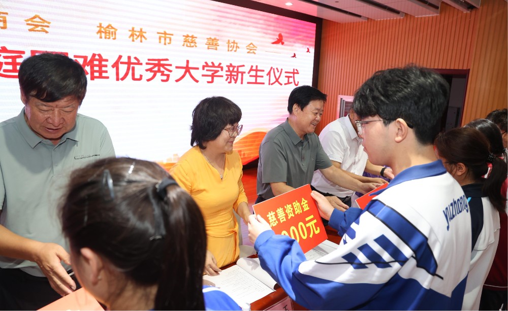 4.出席榆林市侨商会慈善助学仪式的领导向受助学生发放资助金.jpg