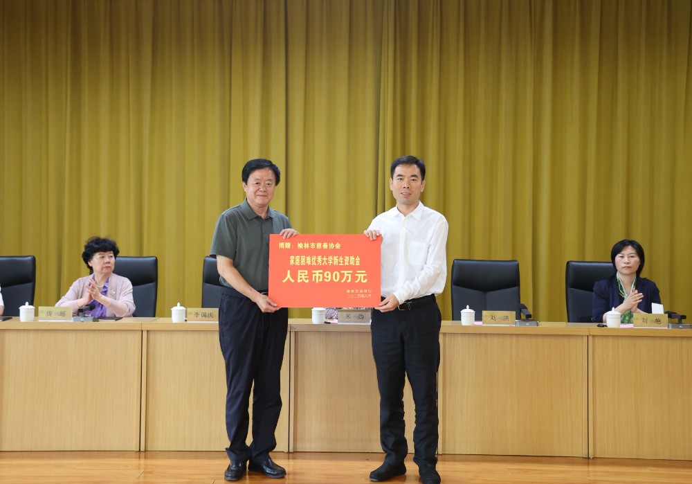 2.榆林农商银行董事长李国庆（右）向榆林市慈善协会会长刘洪（左）递交捐赠牌.jpg
