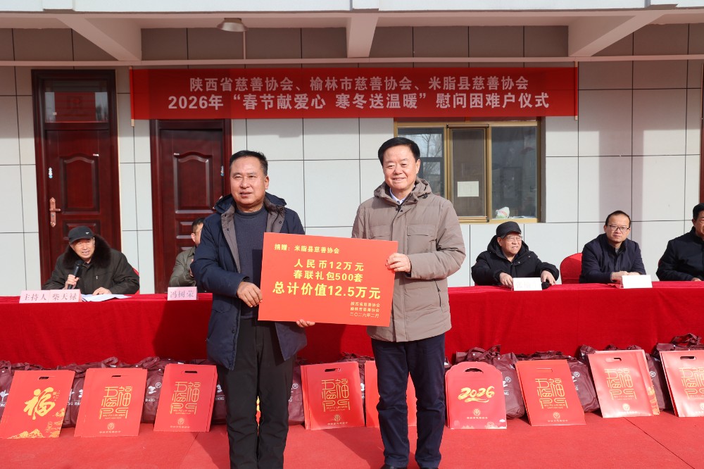 榆林市慈善协会会长刘洪（右）向米脂县慈善协会递交捐赠牌.JPG