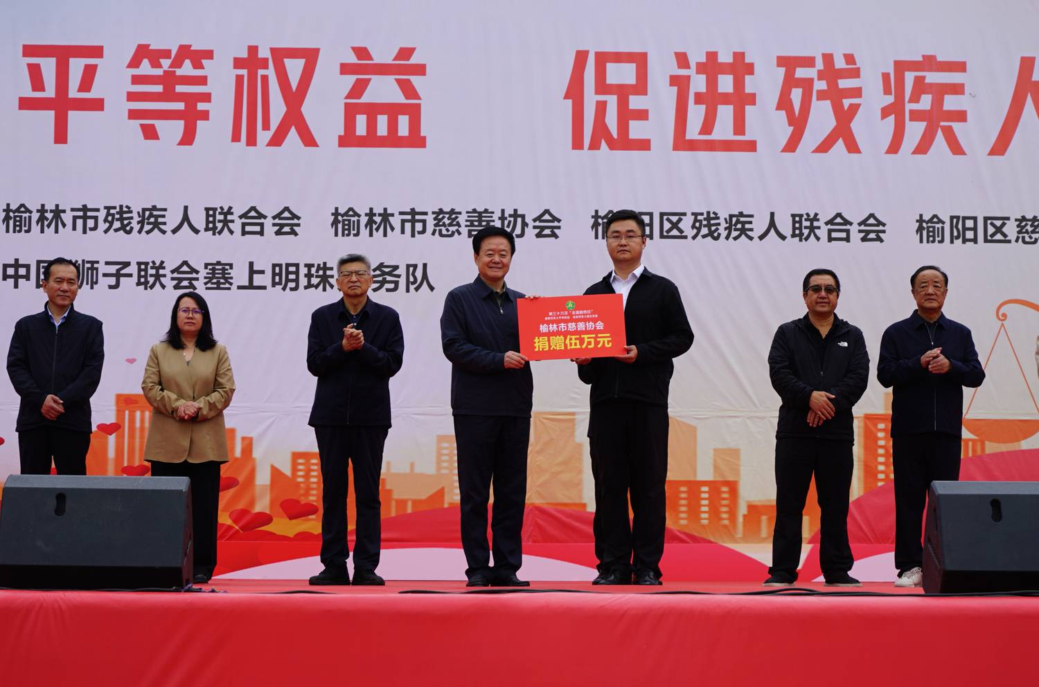 2.榆林市慈善协会会长刘洪向榆林市残疾人康复特殊教育学校递交捐赠牌.jpg