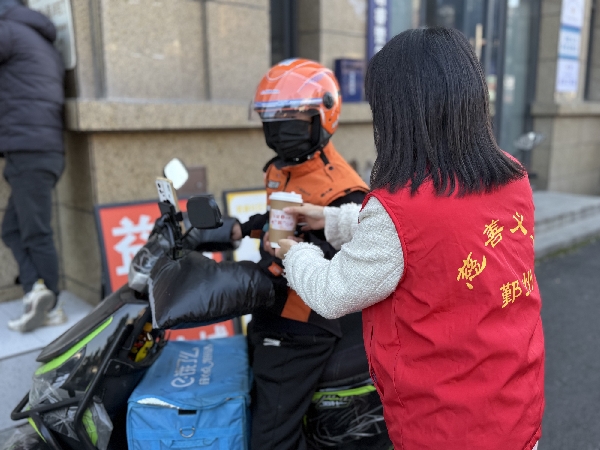 图为慈善义工将热饮递给外卖小哥_副本.jpg 图为慈善义工将热饮递给外卖小哥_副本.jpg
